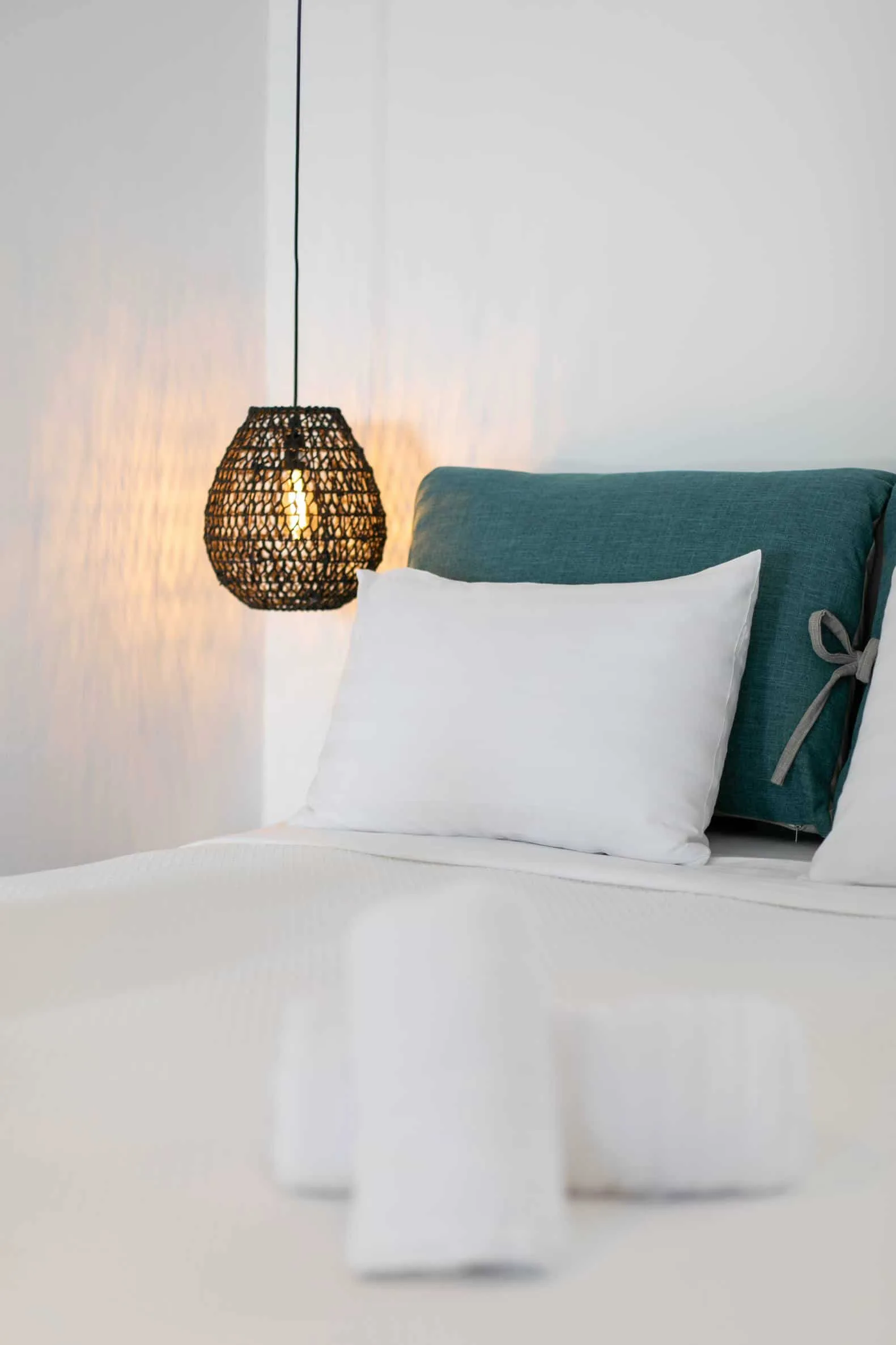 Teal headboard cushion and pendant lamp detail